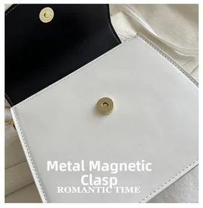 Détail du sac en cuir blanc avec fermoir magnétique doré et coutures premium