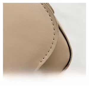 Close-up of saddle bag leather texture with detailed beige contrast stitching detail