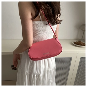 Close-up of pink baguette bag with silver Fashion print on minimalist flap cover