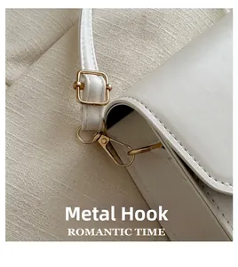 Détail du crochet et boucle en métal doré sur le sac à main en cuir blanc épuré