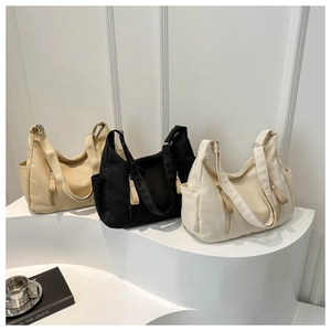 Three canvas tote bags in khaki, black, and cream white displayed on a modern stand