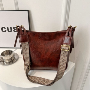 Retro burgundy leather bucket bag with wide embroidered strap and gold hardware