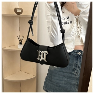 Close-up of the black leather handbag featuring a silver Gothic B buckle and knot detail
