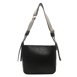Sac seau noir en cuir texturé avec large bandoulière à motifs géométriques élégants