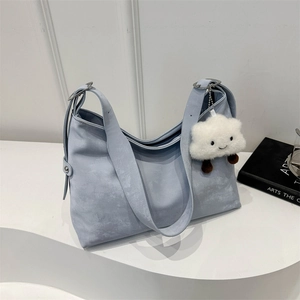 Minimalist light blue tote bag with a soft texture and cute cloud charm on display
