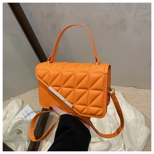 Detail view of the bright orange quilted crossbody bag with stylish silver metal clasp