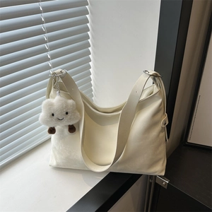 Large cream PU leather tote bag with wide strap and cloud charm in natural light