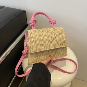 Pink and beige woven crossbody bag with pink leather handle and shoulder strap