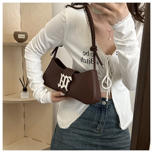 Detailed view of dark brown crescent bag with silver metallic logo and knotted leather strap