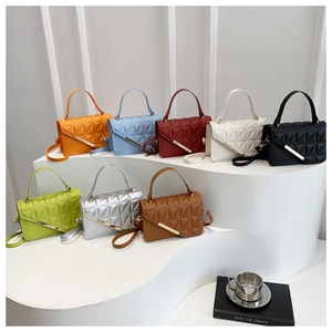 Multiple colors of textured square bags displayed on a white curved tiered stand