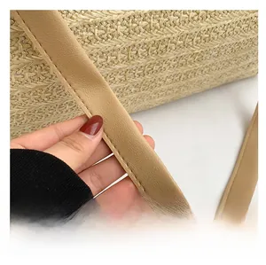 Close-up of contrast woven straw bag with premium synthetic leather shoulder strap and stitching