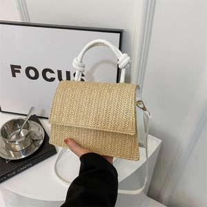 Minimalist woven straw crossbody bag with white faux leather handles and knot details