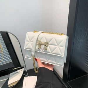 White quilted shoulder bag with gold chain strap and elegant metallic bow detail