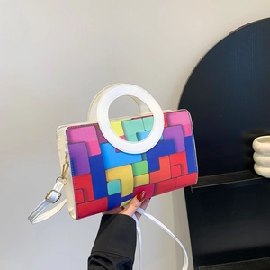 Colorful geometric patchwork crossbody bag with white ring handle and slim shoulder strap