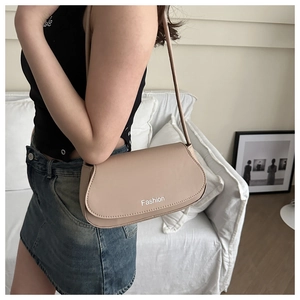Detail of minimalist beige faux leather shoulder bag featuring a Fashion printed cover flap