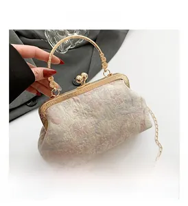 Detail view of pink floral jacquard fabric with gold-tone frame and engraved handle