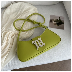 Detailed view of lime green leather baguette bag with gothic silver logo and knotted strap