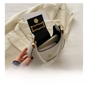 Detailed view of white crocodile pattern hobo bag interior with gold buckle and phone