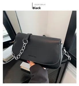 Detailansicht der schwarzen matten Ledertasche mit Silberkette und Logo-Prägung