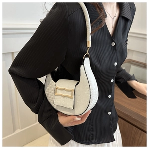 Detail showing white croc-embossed crescent shoulder bag with golden metal buckle