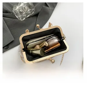 Internal view of the gold clasp evening bag showing capacity for phone and cosmetics