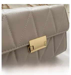 Détail d'un sac à main en similicuir matelassé en V avec un fermoir rotatif doré en métal
