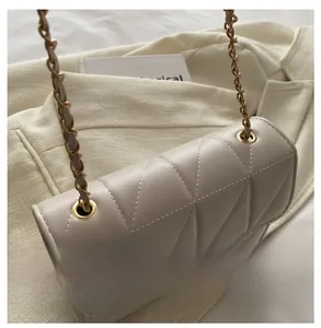 Détails de la pochette matelassée avec chaîne dorée et coutures de précision soignées