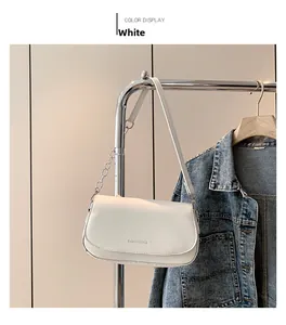 Close-up of white saddle bag with Fashion & Bags embossing and chain strap detail
