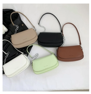 Flat lay of underarm bags in five colors with chain straps and magnet flaps