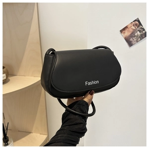 Detail of black faux leather saddle bag with Fashion print and elegant curved flap