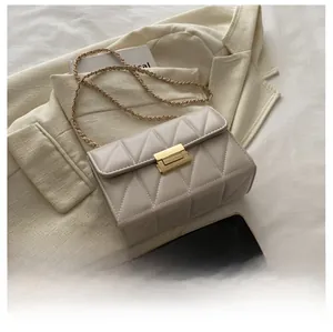Détails du sac matelassé beige avec bandoulière en chaîne dorée et fermoir métallique