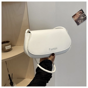 Detail of white leather saddle bag with Fashion text and slender shoulder strap