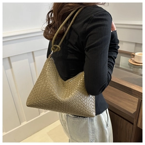 Olive green woven leather hobo bag with knotted strap detail shown on model shoulder