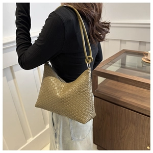 Side view of olive green woven leather hobo bag with knotted shoulder strap on model