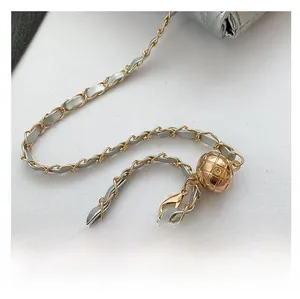 Detail of silver bag chain strap with gold metal mesh adjustment ball and lobster clasp