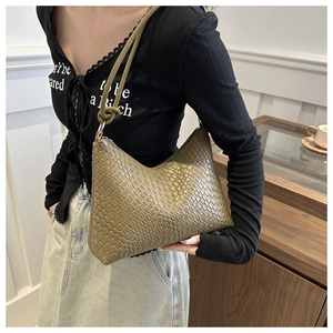 Detail of olive green woven texture on a crescent shoulder bag with knotted strap