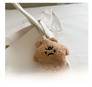 Gros plan d'un charme de sac en peluche marron en forme d'étoile avec visage grognon