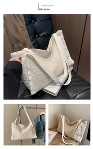 Close-up of creamy white woven straw tote bag featuring contrast white leather handles