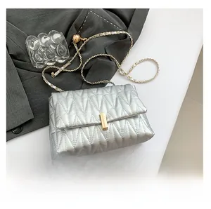 Detail view of silver quilted PU leather crossbody bag with golden chain and clasp