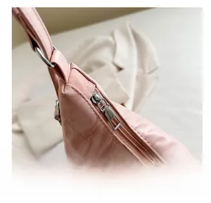 Détail de la fermeture éclair métallique lisse d'un sac à bandoulière rose à nœud
