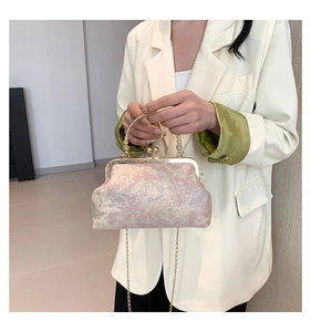 Dettaglio del tessuto jacquard floreale e chiusura dorata su una borsa a mano vintage