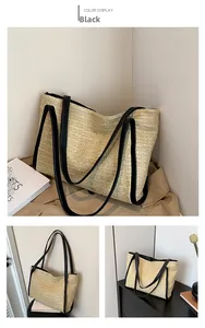 Close-up of a rustic woven straw tote bag with black leather straps and elegant texture