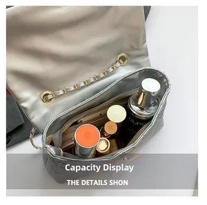 Internal storage view of silver quilted chain bag with cosmetics inside for capacity