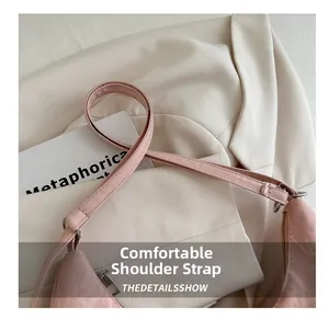 Détail de la bandoulière en cuir rose et de la boucle sur le sac à main papillon