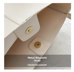 Détail du sac cabas en cuir crème avec une boucle magnétique métallique de haute qualité
