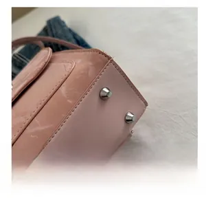 Detail view of the pink leather backpack base featuring silver metal anti-wear studs