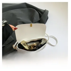 Interior view of white leather crossbody bag showing capacity for phone and cosmetics
