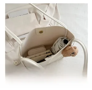 Intérieur spacieux du sac hobo blanc montrant la capacité pour parapluie et téléphone