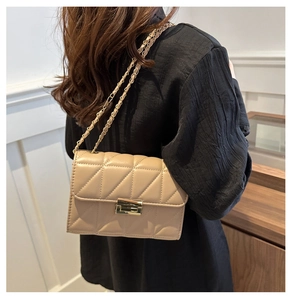Vue détaillée d'un sac à bandoulière matelassé beige avec fermoir métallique doré