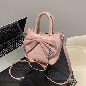 Chic pink bucket bag with a large bow detail and silver chain strap for women